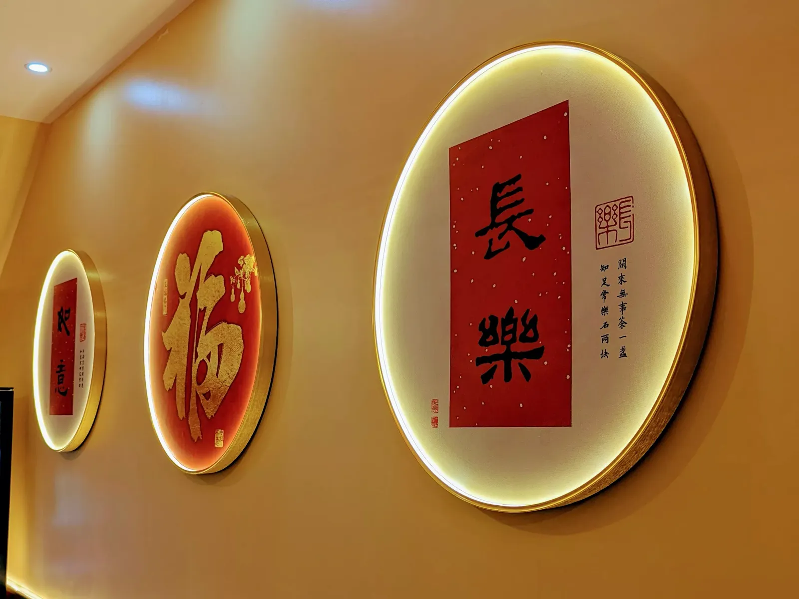Calligraphies chinoises dans des cadres ronds lumineux sur un mur doré